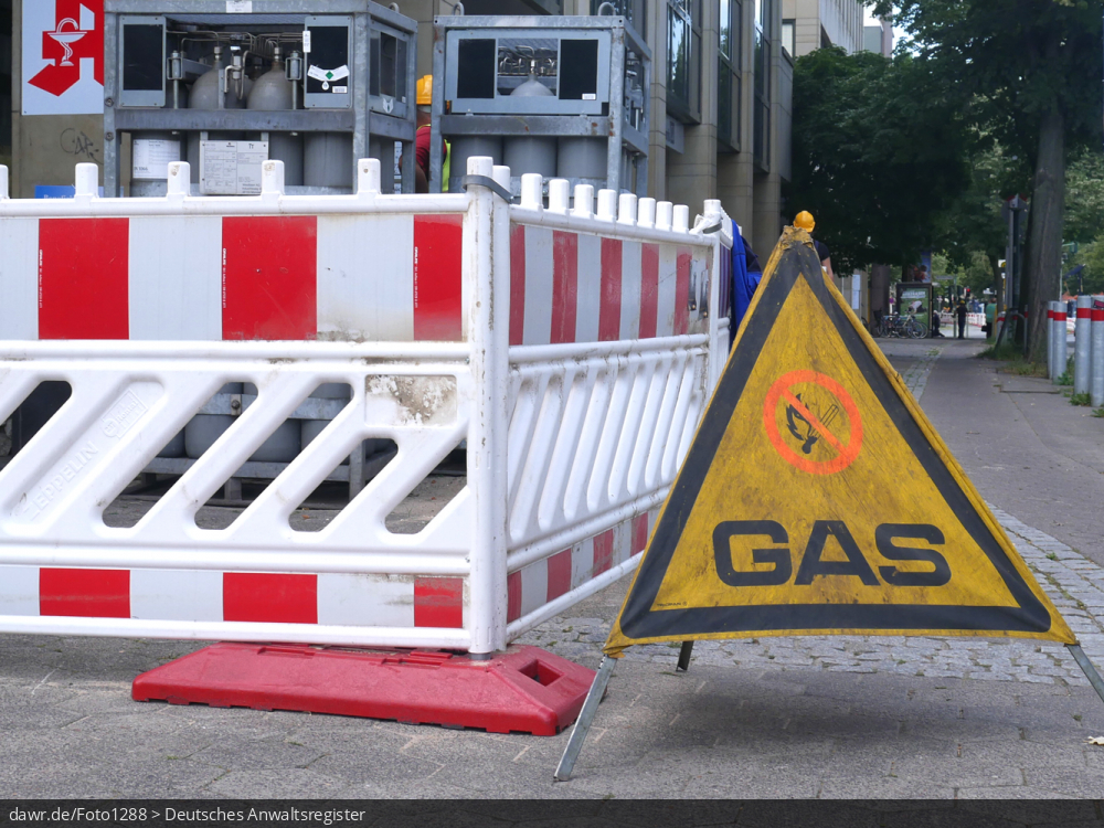 Dieses Foto zeigt eine Baustelle auf einem Fußweg, vor der ein Warnschild steht, welches vor möglicherweise austretendem Gas warnt. Dieses Bild eignet sich u.a. gut als symbolische Darstellung für alle Themen rund um Bauarbeiten und die Gasversorgung.