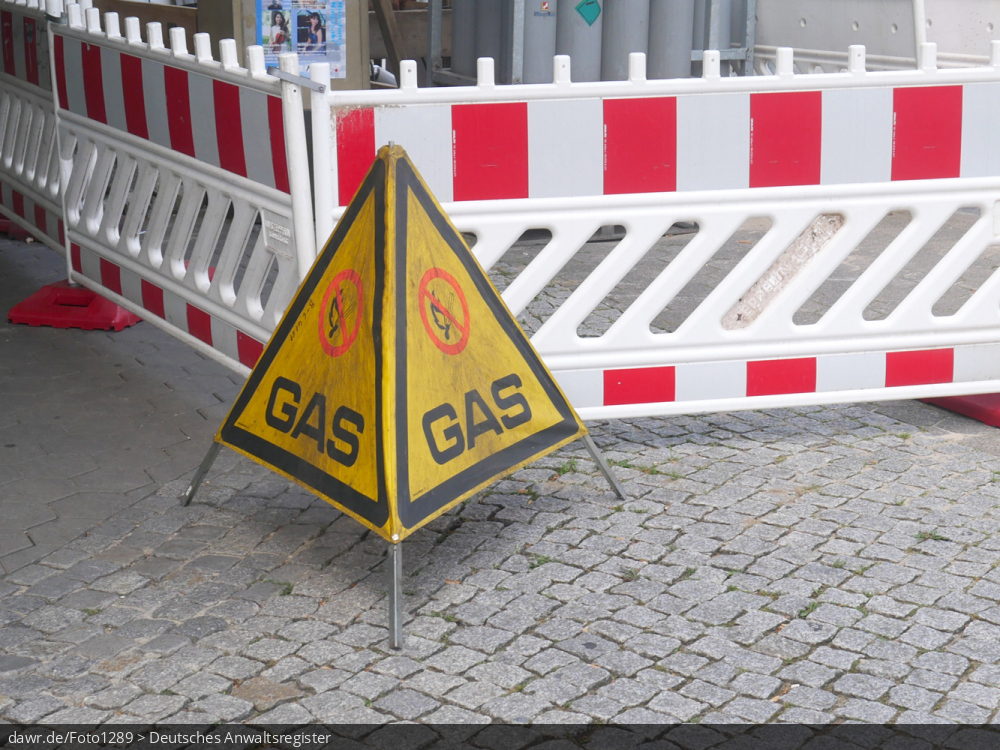 Dieses Foto zeigt eine Baustelle auf einem Fußweg, vor der ein Warnschild steht, welches vor möglicherweise austretendem Gas warnt. Dieses Bild eignet sich u.a. gut als symbolische Darstellung für alle Themen rund um Bauarbeiten und die Gasversorgung.
