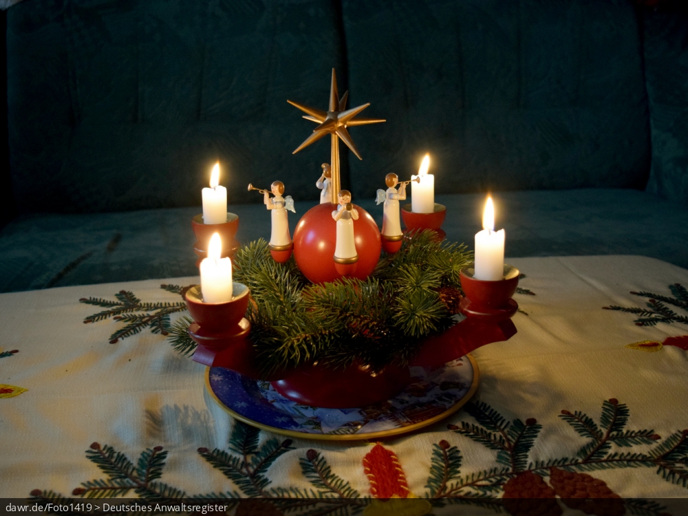 Dieses Foto zeigt einen mit Kerzen beleuchteten Adventskranz, wie er im sächsischen Erzgebirge hergestellt wird. Heutzutage ist solche Volkskunst in ganz Deutschland ein beliebter Weihnachtsschmuck. Dieses Bild eignet sich gut als symbolische Darstellung für alle Themen rund um Weihnachten und speziell zu rechtlichen Fragen bez. der Weihnachtsdekoration.