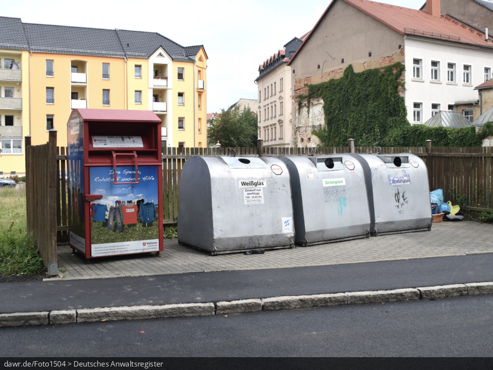 Das Foto zeigt neben einem Altkleider- drei Altglascontainer für Weiß-, Grün- und Braunglas, wie er für das Einsammeln von alten Flaschen und Gläsern an vielen Straßen stehen. Dieses Bild eignet sich gut als symbolische Darstellung für das Thema Recycling und speziell Altglasrecycling.