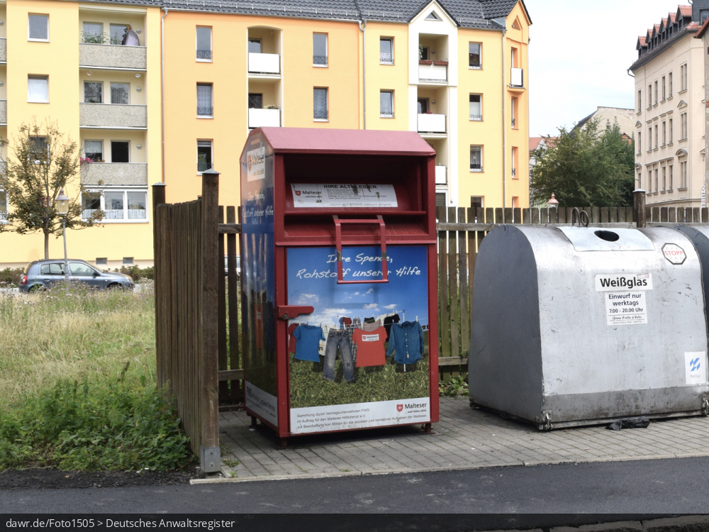 Das Foto zeigt einen Altkleidercontainer, wie er u.a. von gemeinnützigen Organisationen zum Sammeln von alter, noch tragbarer Kleidung an vielen Straßen steht. Dieses Bild eignet sich gut als symbolische Darstellung für das Thema Recycling und speziell Altkleidersammlung.