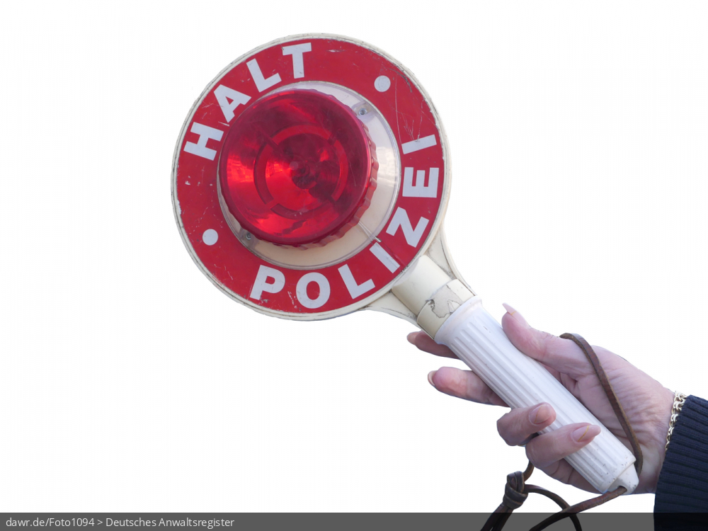 Dieses Foto zeigt einen Anhaltestab mit den Aufschriften „Halt“ und „Polizei“, wie er von Polizisten bei Fahrzeugkontrollen eingesetzt wird und auch gern als Polizeikelle bezeichnet wird. Der Anhaltestab wird von einer Frauenhand in der passenden Position gehalten. Dieses Bild eignet sich gut als Symbolisierung von Fahrzeugkontrollen oder anderen Verkehrskontrollen durch die Polizei.