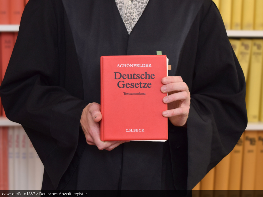 Dieses Foto zeigt einen Rechtsanwält*in mit einem Gesetzbuch in der Hand. Diese Darstellung eignet sich allgemein gut für rechtliche Themen.