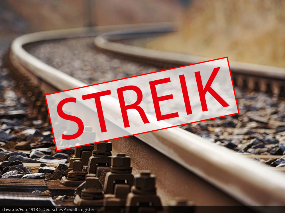 Dieses Bild zeigt eine Gleisanlage, wie sie bei der Bahn in praktisch jeder größeren Stadt zu finden ist. Im Vordergrund sieht ein Schild mit dem Begriff „Streik“. Es handelt sich um eine gut geeignete symbolische Darstellung für das Thema Streik bei der Bahn.