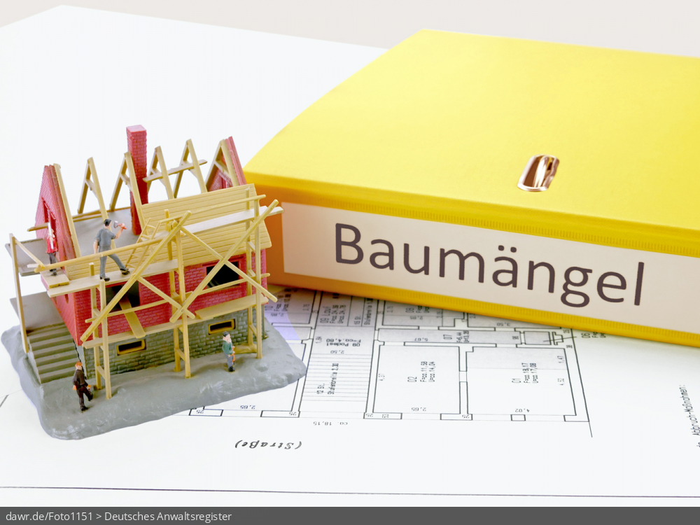 Dieses Foto zeigt einen gelben Aktenordner, mit der Beschriftung „Baumängel“, wobei der Ordner auf einem Bauplan liegt. Ebenfalls auf diesem Bauplan ist ein kleines Modellhaus zu sehen, welches ein Gebäude im Rohbau darstellt. Dieses Bild eignet sich gut als symbolische Darstellung der Themen „Baumängel“ und „Haftung durch Baufirmen“.