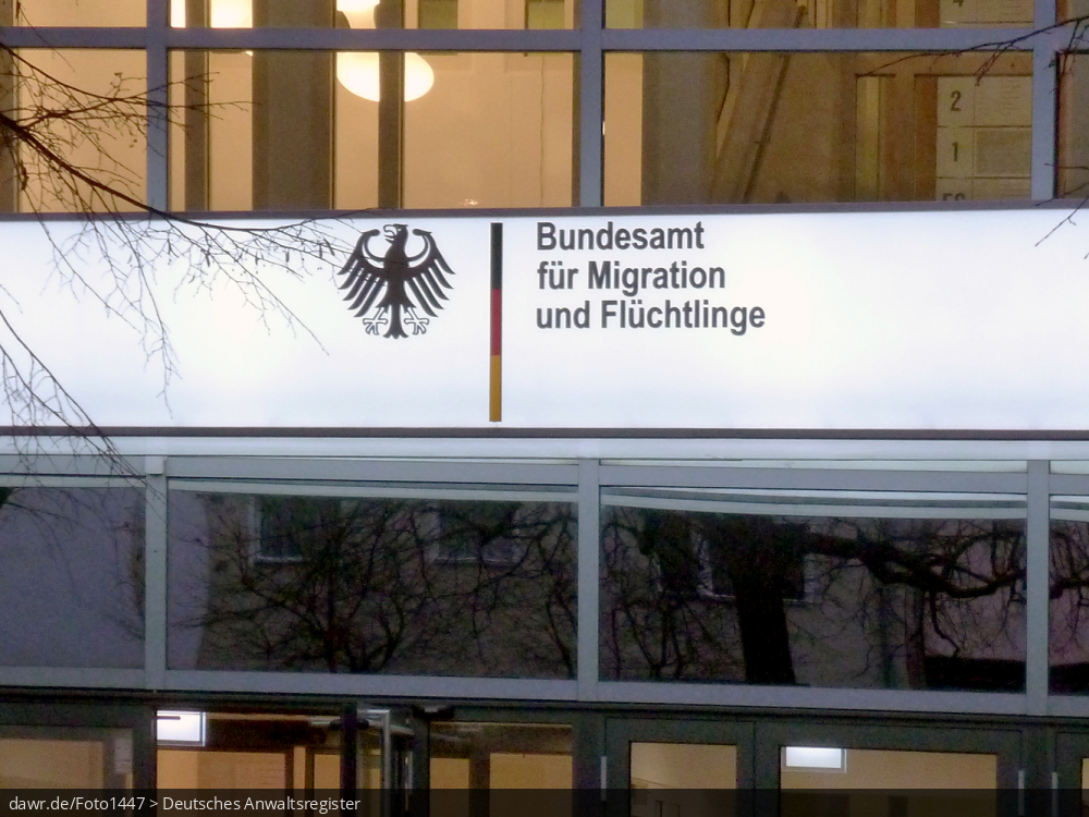 Dieses Foto zeigt ein Neonschild an der Außenfassade einer Niederlassung des Bundesamt für Migration und Flüchtlinge (BAMF) mit dem Bundesadler und passendem Schriftzug der Behörde. Das Bundesamt ist zentrale Migrationsbehörde in Deutschland mit Kompetenzen in den Bereichen Migration, Integration, Asyl, Flüchtlingsschutz, Integration und Rückkehr. Dieses Bild eignet sich so gut als symbolische Darstellung für alle Themen in Zusammenhang mit der Einwanderung von Flüchtlingen bzw. allgemein der Migration nach Deutschland.