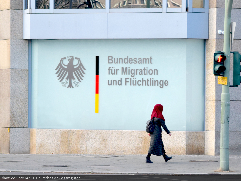 Dieses Foto zeigt die Außenfassade einer Niederlassung des Bundesamt für Migration und Flüchtlinge (BAMF) mit dem Bundesadler und passendem Schriftzug der Behörde. Das Bundesamt ist zentrale Migrationsbehörde in Deutschland mit Kompetenzen in den Bereichen Migration, Integration, Asyl, Flüchtlingsschutz, Integration und Rückkehr. Dieses Bild eignet sich so gut als symbolische Darstellung für alle Themen in Zusammenhang mit der Einwanderung von Flüchtlingen bzw. allgemein der Migration nach Deutschland.
