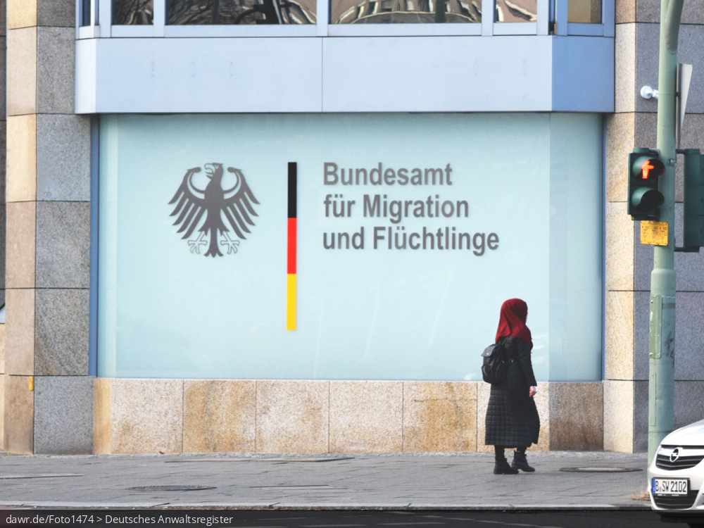 Dieses Foto zeigt die Außenfassade einer Niederlassung des Bundesamt für Migration und Flüchtlinge (BAMF) mit dem Bundesadler und passendem Schriftzug der Behörde. Das Bundesamt ist zentrale Migrationsbehörde in Deutschland mit Kompetenzen in den Bereichen Migration, Integration, Asyl, Flüchtlingsschutz, Integration und Rückkehr. Dieses Bild eignet sich so gut als symbolische Darstellung für alle Themen in Zusammenhang mit der Einwanderung von Flüchtlingen bzw. allgemein der Migration nach Deutschland. Dieses Foto zeigt die Außenfassade einer Niederlassung des Bundesamt für Migration und Flüchtlinge (BAMF) mit dem Bundesadler und passendem Schriftzug der Behörde. Das Bundesamt ist zentrale Migrationsbehörde in Deutschland mit Kompetenzen in den Bereichen Migration, Integration, Asyl, Flüchtlingsschutz, Integration und Rückkehr. Dieses Bild eignet sich so gut als symbolische Darstellung für alle Themen in Zusammenhang mit der Einwanderung von Flüchtlingen bzw. allgemein der Migration nach Deutschland.
