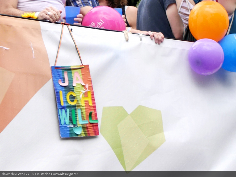 Dieses Foto zeigt eine kleines Transparent im Stil einer Regenbogenfahne mit der Aufschrift „Ja ich will“, womit es sich gut als symbolische Darstellung für das Thema Ehe für Alle oder Ehe für gleichgeschlechtliche Paare eigent.