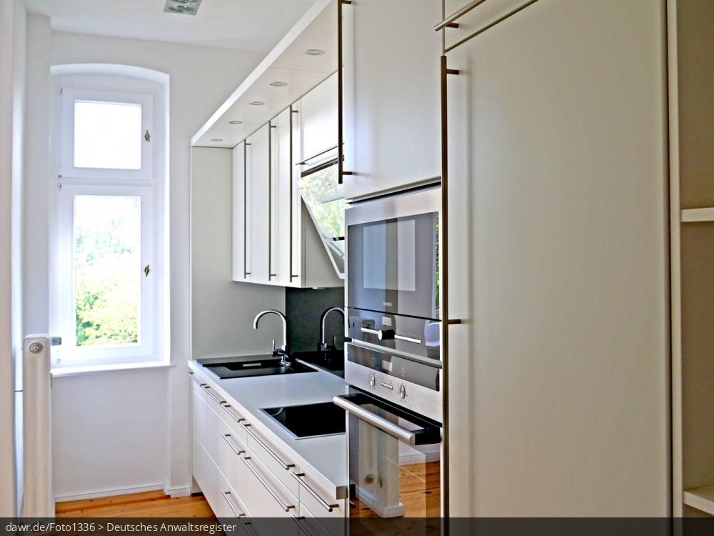 Das Foto zeigt eine moderne Einbauküche mit Abwaschplatz, Herd und seperat installiertem Backofen. Auch die oben montierten LED-Strahler zeugen von einer zeitgemäßen Ausstattung.