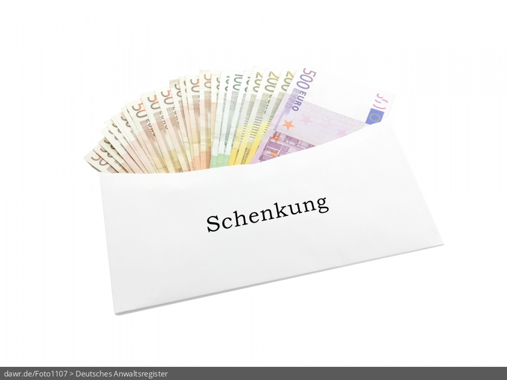 Dieses Foto zeigt einen Briefumschlag, der mit den vielen verschiedenen Banknoten aus dem Euroraum gefüllt ist. Auf dem Umschlag ist „Schenkung“ zu lesen. Als symbolische Darstellung für die Themen Schenkung, Erbschaft und Steuerhinterziehung eignet sich dieses Bild gut.
