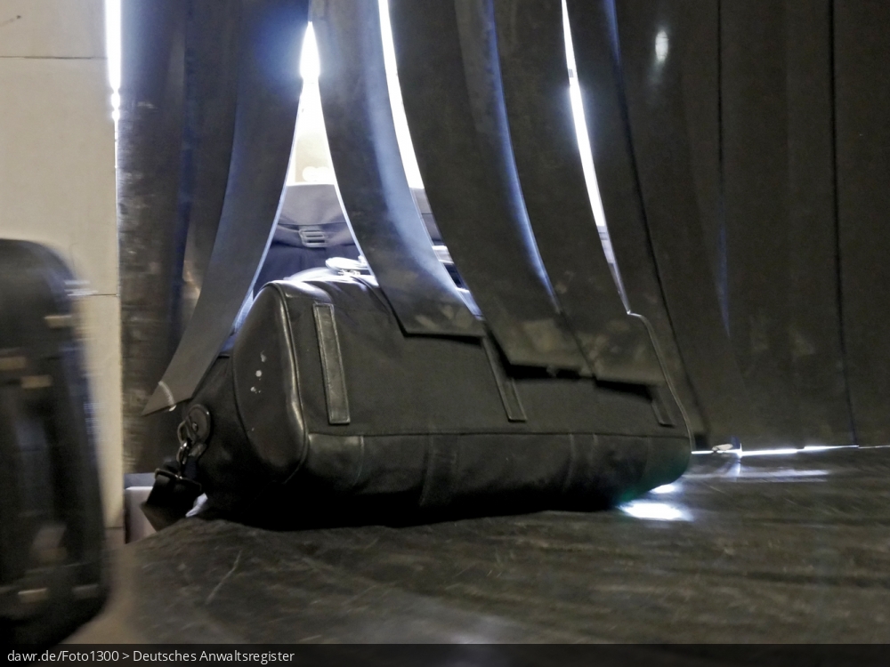 Das Foto zeigt eine Tasche auf einem Gepäckband am Flughafen. Dieses Bild eignet sich gut als symbolische Darstellung für Themen rundum den Flugverkehr und Flugreisen, einschließlich Flugverspätungen.