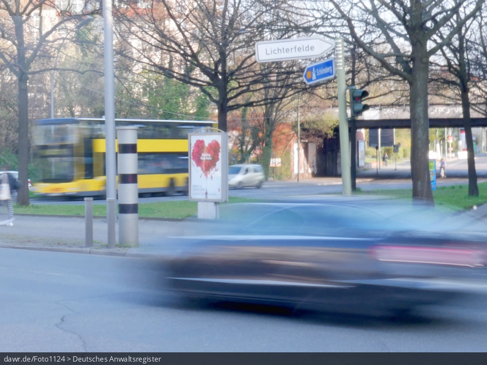 Dieses Foto zeigt eine große Straßenkreuzung, an der eine Geschwindigkeitsüberwachungsanlage vom Typ Vitronic Poliscan speed aufgestellt wurde. Auch wenn hier ein spezieller Typ von Geschwindigkeitsüberwachungsanlage dargestellt wird, ist es möglich dieses Bild als symbolische Darstellung für Themen in Zusammenhang mit Geschwindigkeitsverstößen und ihren Konsequenzen zu verwenden.