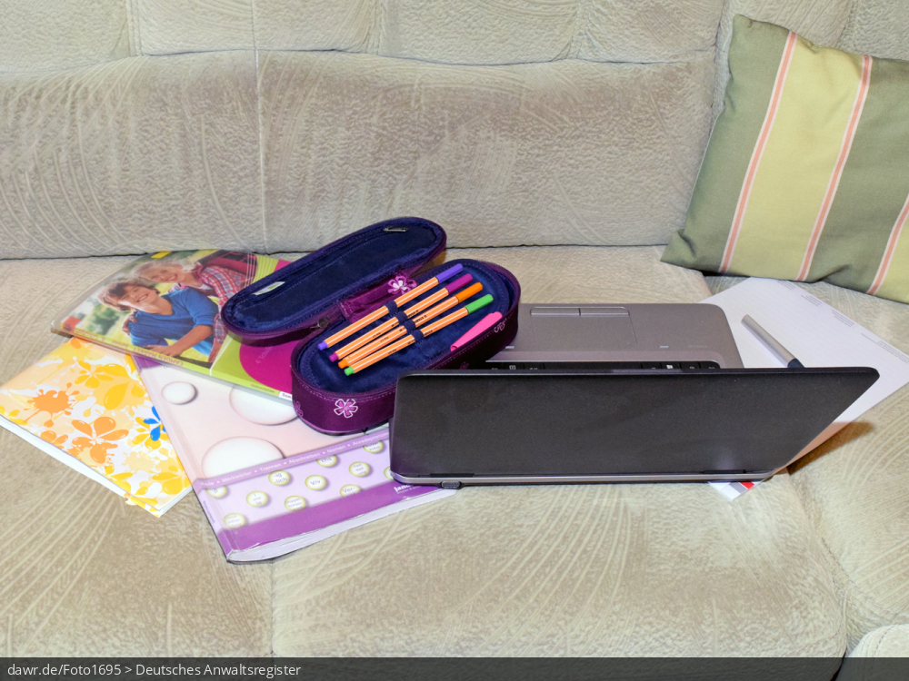Dieses Foto zeigt ein Sofa auf dem ein Notebook, verschiedene Schulbücher und -hefte, eine Federtasche mit diversen Stiften und ein Füller zu sehen ist. Ergänzt wird die Szenerie durch ein Sofakissen. Dieses Bild eignet sich gut als symbolische Darstellung für das Thema Home-Scooling oder besser Schule zu Hause, wie es im Zusammenhang mit der Corona-Pandemie deutschlandweit notwendig geworden ist.