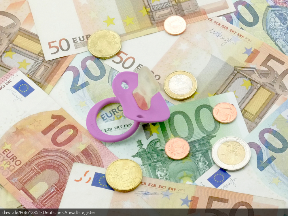 Dieses Foto zeigt mehrere Geldscheine verschiedener Werte, welche auf einer Fläche verteilt wurden. Auf dem Geld liegt ein rosa Schnuller, wie ihn Kleinkinder benutzen. Dieses Bild eignet sich gut als symbolische Darstellung für das Thema Kindergeld.