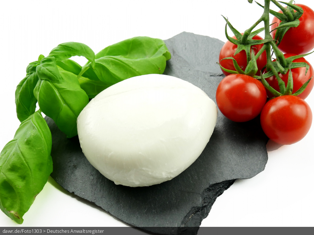 Das Foto zeigt einen Mozarella, der auf einer Schieferplatte liegt.
Als Garnierung wurde Basilikum und Cocktailtomaten verwendet.
