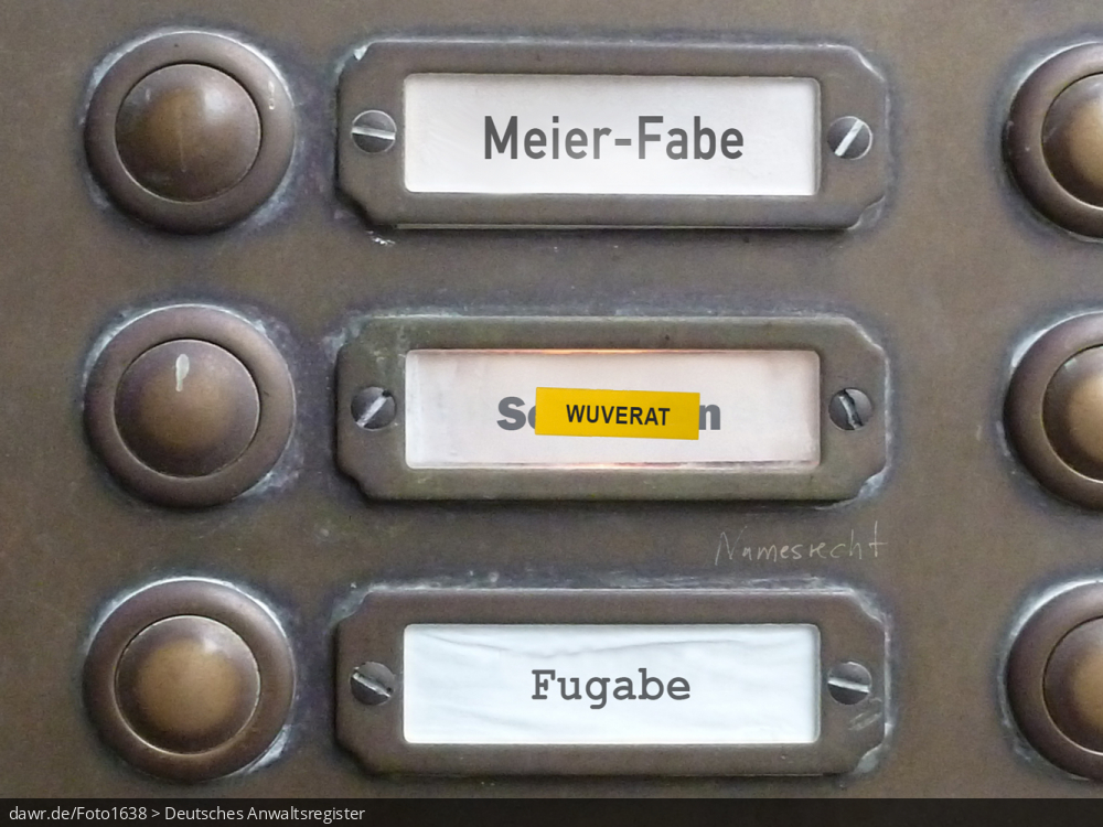 Dieses Foto zeigt einen Teil des Klingelschilds eines Altbau-Mehrfamilienhauses, wobei die Namen „Meier-Fabe“, „Wuverat“ und „Fugabe“ zu lesen sind. Mit dem Namen „Wuverat“ wurde ein anderer Name überklebt, wie man es bspw. nach einer Scheidung oder einem Umzug machen würde. Auf die Klingeltafel selbst wurde der Schriftzug „Namensrecht“ gekritzelt. Diese symbolische Darstellung eignet sich gut für alle Themen rund um das Namensrecht, speziell bez. des Umgangs mit dem Familiennamen bei einer Scheidung.