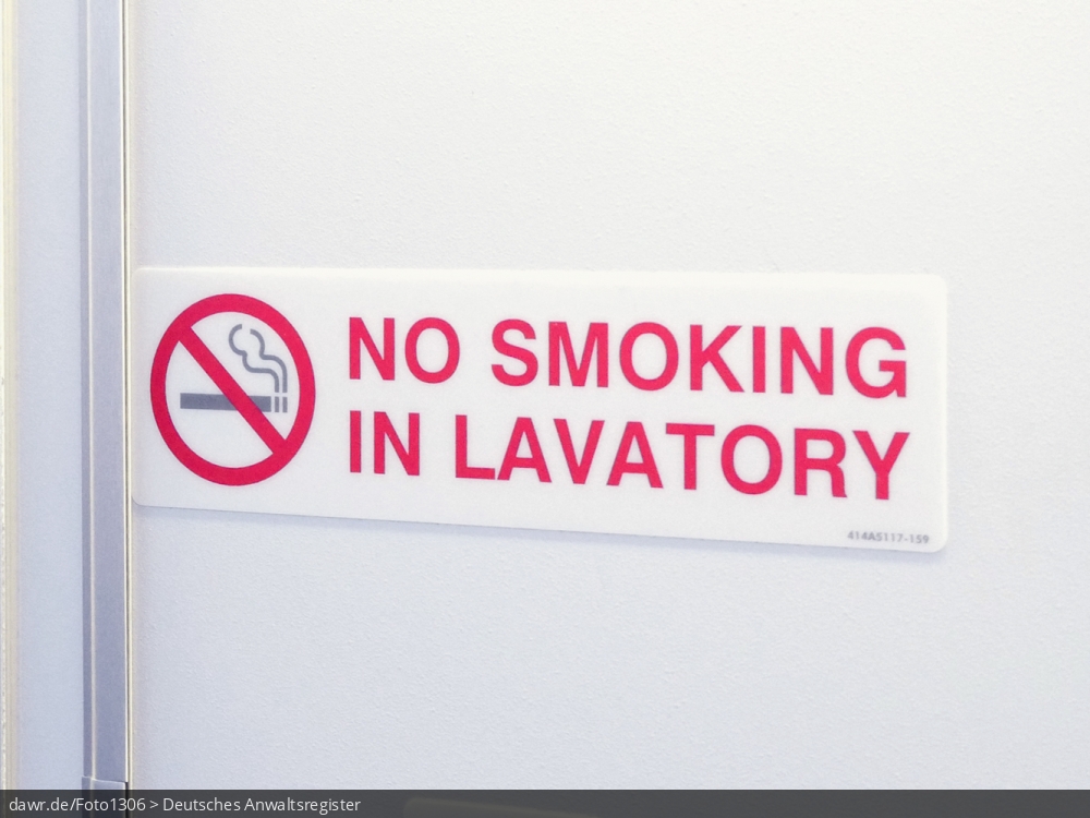 Das Foto zeigt ein Schild, wie es sich an Flugzeugtoiletten befindet und auf das geltende Rauchverbot hinweist. Dieses Bild eignet sich gut als symbolische Darstellung für die Themen Nichtrauchschutz und Flugsicherheit.