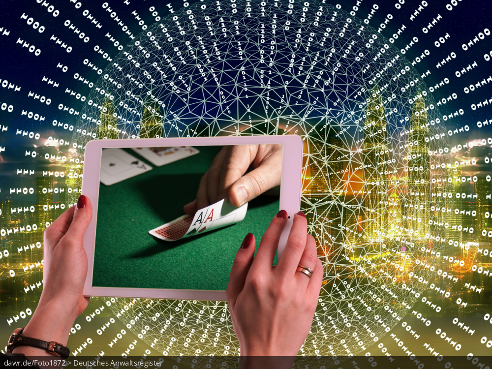 Diese Fotomontage zeigt die Skyline einer Großstadt, ergänzt mit einem abstrakten Netzwerk aus Nullen und Einsen. Im Vordergrund sieht man ein Tablet, auf dessen Bildschirm ein Ausschnitt aus einer Poker-Partie zu sehen ist. Diese Darstellung eignet sich gut für Themen im Zusammenhang mit Online-Glücksspielen.