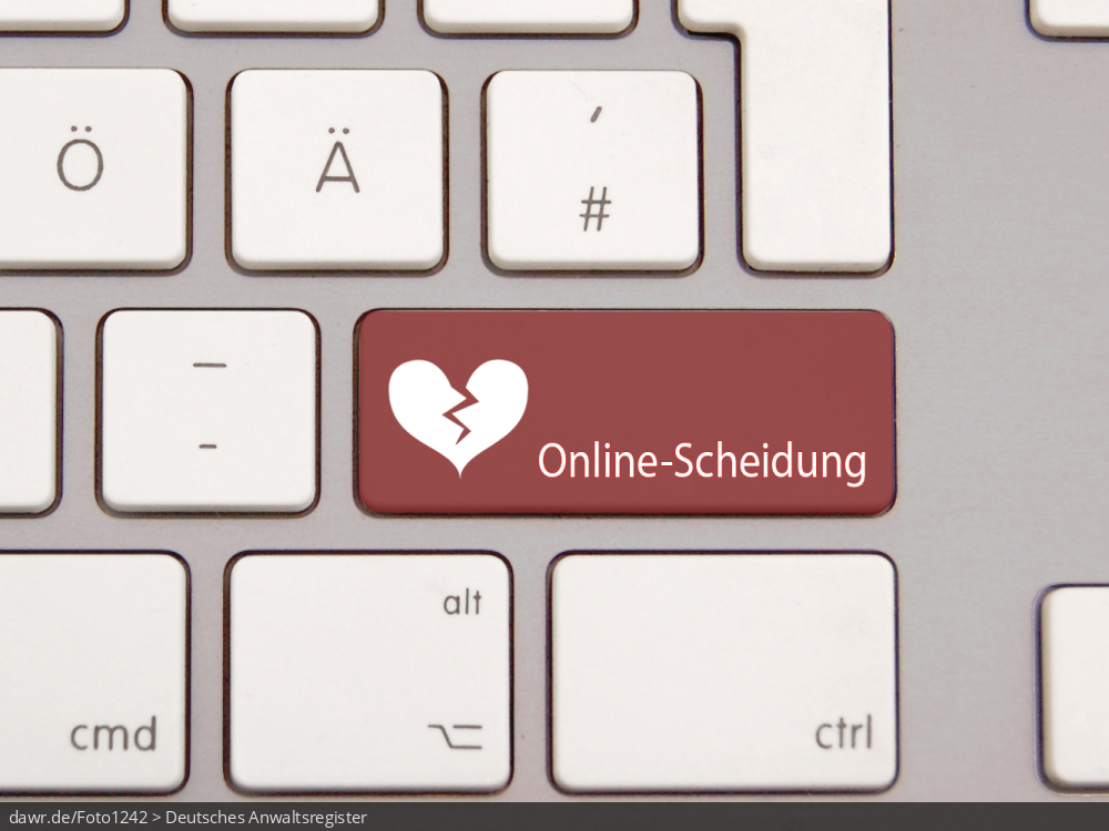 Dieses Foto zeigt eine moderne Tastatur mit einer speziellen, dunkelroten Taste. Auf dieser Taste ist ein gebrochenes Herz und der Schriftzug „Online-Scheidung“ aufgedruckt. Diese Grafik eignet sich gut als symbolische Darstellung für das Thema Scheidung, wobei der Scheidungsantrag über das Internet beim Rechtsanwalt eingereicht und abgewickelt wird.