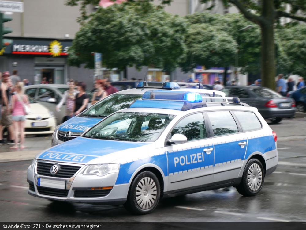 Dieses Foto zeigt zwie Streifenwagen der Polizei mit aktiviertem Blaulicht an einem Einsatzort. Dieses Bild eignet sich gut als symbolische Darstellung für alle Themen rund um die Polizei und ihre Einsätze.