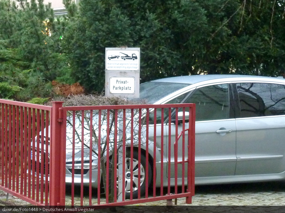Dieses Foto zeigt ein Auto auf einem als Privatparkplatz markierten Stellplatz auf dem Hof eines Wohngebäudes. Diese Abbildung eignet sich gut als symbolische Darstellung für Themen in Zusammenhang mit Parken in der Stadt und Vermieter- bzw. Mieterrechten.