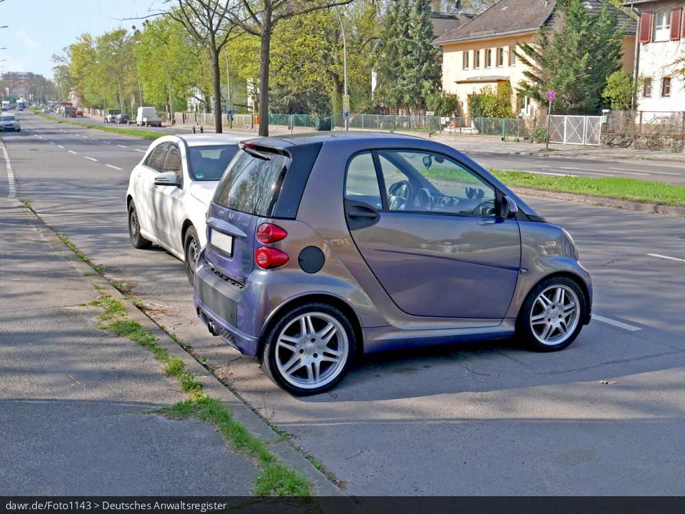 Dieses Foto zeigt einen Smart, der quer zur Fahrbahn parkt. Dieses Bild eignet sich gut als symbolische Darstellung für die rechtliche Diskussion darüber, ob das Querparken mit sehr kurzen Autos erlaubt ist.