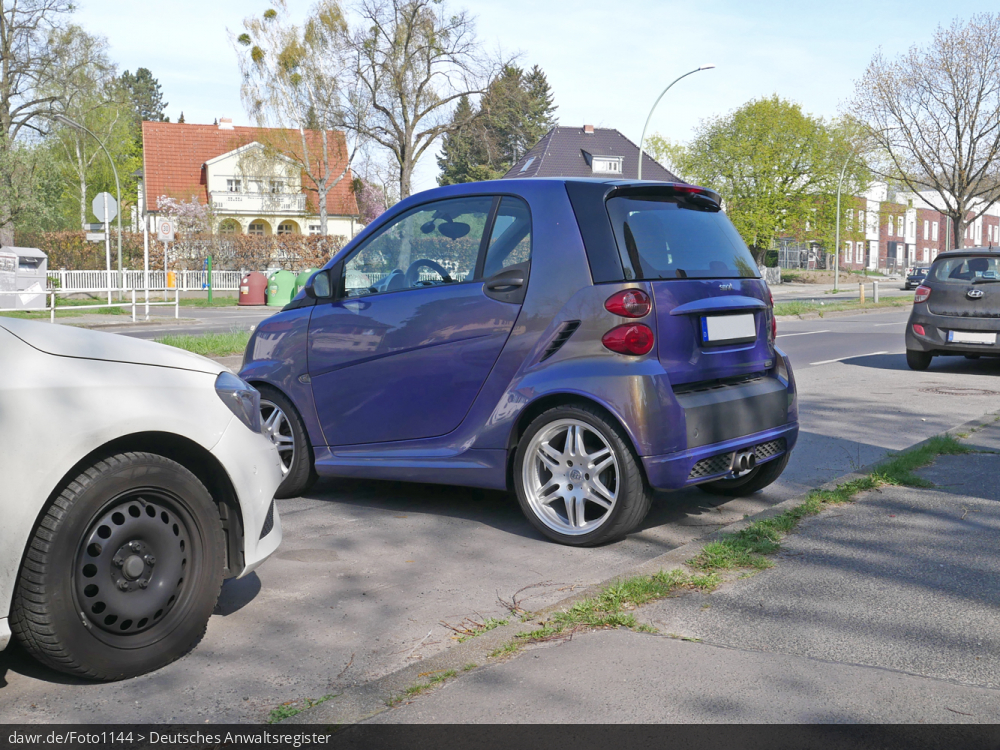 Dieses Foto zeigt einen Smart, der quer zur Fahrbahn parkt. Dieses Bild eignet sich gut als symbolische Darstellung für die rechtliche Diskussion darüber, ob das Querparken mit sehr kurzen Autos erlaubt ist.