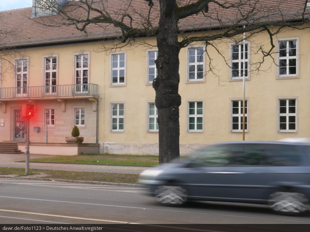 Dieses Foto zeigt eine Straße, an der eine Geschwindigkeitsüberwachungsanlage vom Typ TRAFFIPAX TraffiPho aufgestellt wurde, welche gerade ein Auto blitzt. Auch wenn hier ein spezieller Typ von Geschwindigkeitsüberwachungsanlage dargestellt wird, ist es möglich dieses Bild als symbolische Darstellung für Themen in Zusammenhang mit Geschwindigkeitsverstößen und ihren Konsequenzen zu verwenden.