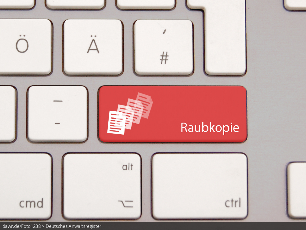 Dieses Foto zeigt eine moderne Tastatur mit einer speziellen, roten Taste. Auf dieser Taste sind drei stilisierte Dokumente und der Schriftzug „Raubkopie“ aufgedruckt. Diese Grafik eignet sich gut als symbolische Darstellung für die rechtlichen Konsequenzen von Raubkopien.