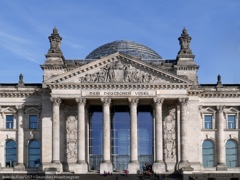 Dieses Foto zeigt das Hauptportal des Reichstagsgebäude (auch Reichstag genannt; offiziell aber: Plenarbereich Reichstagsgebäude) am Platz der Republik in Berlin. Die begehbare Glaskuppel, seit dem großen Umbau zum Ende der 90er Jahre das Wahrzeichen des Reichstags, ist besonders gut zu erkennen. Seit 1999 hat der Deutschen Bundestag hier seinen Sitz. Der Reichstag beherbergt nicht nur den Bundestag, sondern ist seit 1994 auch der Ort an dem die Bundesversammlung zur Wahl des deutschen Bundespräsidenten zusammentritt.