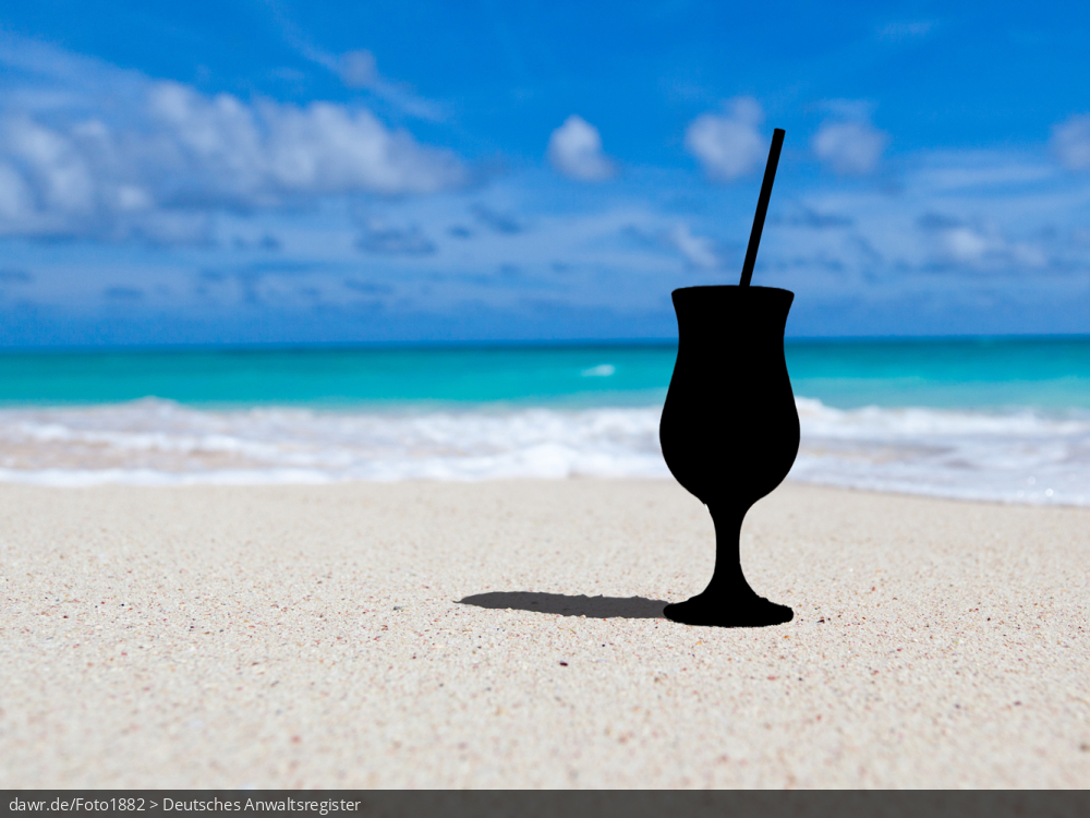 Dieses Foto zeigt einen Strand in der Karibik, auf dem ein Cocktail stehen sollte. Allerdings ist dieser nur als Silhouette dargestellt, als wenn er ausradiert wurde. Diese Darstellung eignet sich wegen dem Ausradieren gut für das Thema Reiserücktritt.
