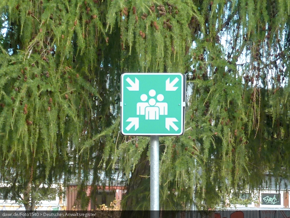 Dieses Foto zeigt ein Schild, mit dem Sammelstellen in bzw. vor öffentlichen Gebäuden markiert werden. Sammelstellen werden festgelegt, um in einem Notfall die geordnete Evakuierung des Gebäudes über die Notausgänge sicher zu stellen. Diese Bild ist eine passende Illustration für alle Fragen im Zusammenhang mit Notfallplänen zur Evakurierung von Gebäuden.