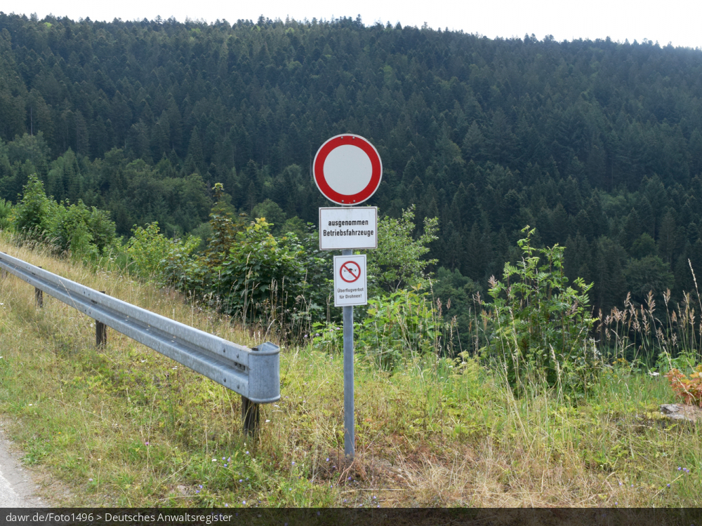 Dieses Foto zeigt ein Verbotsschild mit der Aufschrift „Überflugverbot für Drohnen“ als Ergänzung zu einem Durchfahrtsverbot für Nicht-Betriebsfahrzeuge. Solche Schilder finden sich oft im Bereich durch den Einsatz von Drohnen besonders gefährdeter Orte, wie Flughäfen oder auch Staumauern.
