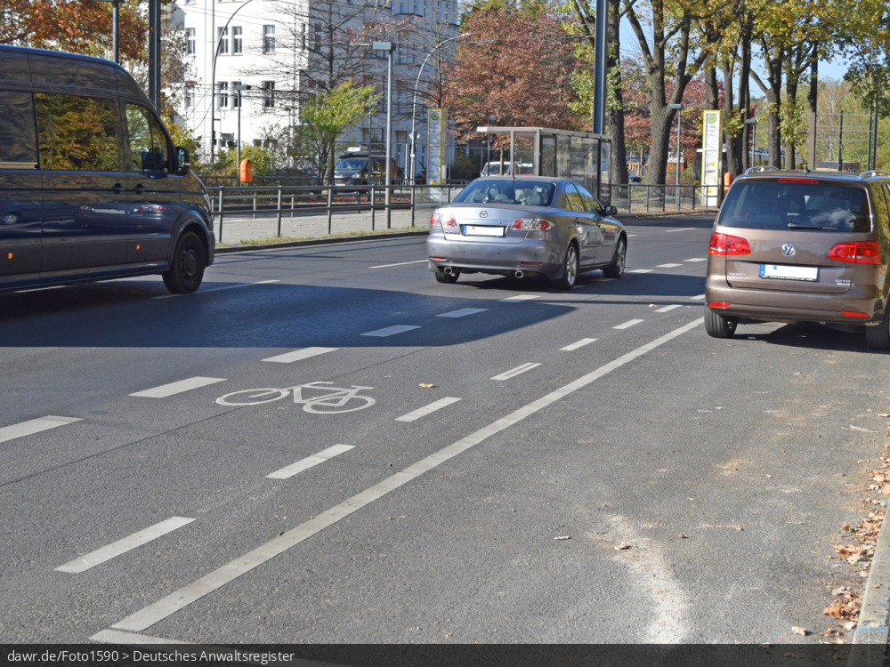 Dieses Foto zeigt einen Schutzstreifen in einer Großstadt. Mit einer unterbrochenen dünnen Linie und dem Sinnbild eines Fahrrades wird der Schutzstreifen in Deutschland von der Fahrbahn für Kraftfahrzeuge abgetrennt. Als Angebotsstreifen oder Suggestivstreifen wird der Schutzstreifen auch gerne bezeichnet. Im Gegensatz zum Radfahrstreifen gibt es beim Schutzstreifen keine Nutzungspflicht für die Radfahrer. Auch ist es anderen Fahrzeugen bei Bedarf zu überfahren, solange der Radverkehr nicht gefährdet wird. Dieses Bild ist gut als symbolhafte Darstellung für die Förderung der Fahrradnutzung in Städten geeignet.