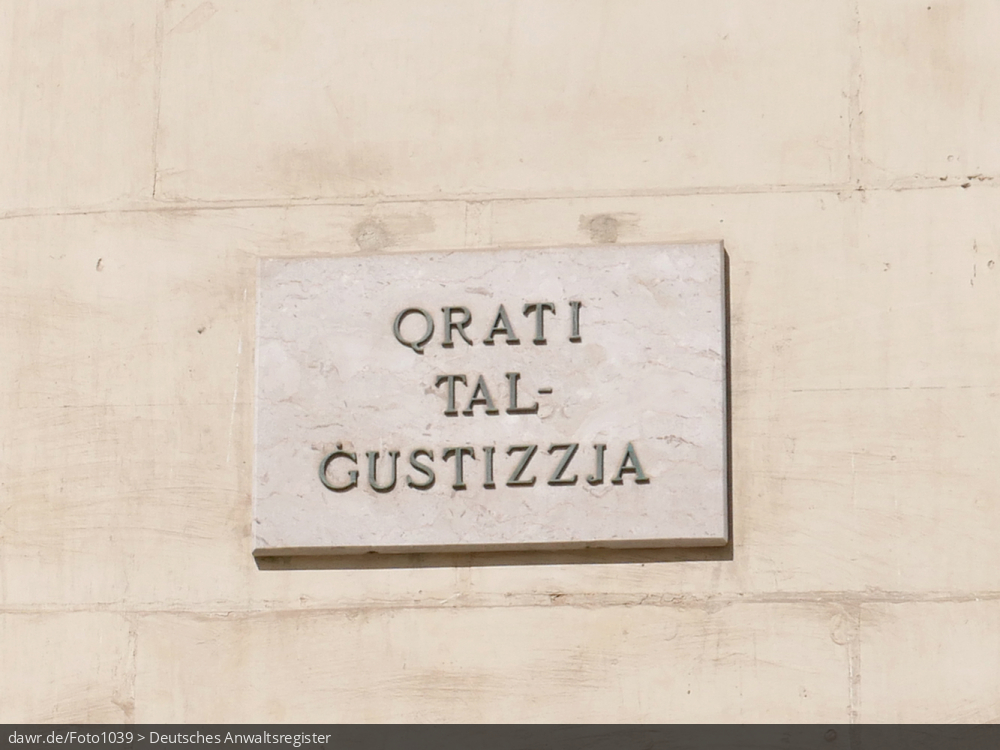 Dieses Foto zeigt eine Steintafel mit der Aufschrift „QRATI TALGUSTIZZJA“. Diese befindet sich am Gerichtsgebäude „Courts Of Justice“ in der Altstadt von Valetta auf der Insel Malta. Das Gerichtsgebäude in der Republic Street wurde im neoklassizistischen Stil zwischen 1965 und 1971 erbaut und beherbergt verschiedene Gerichte.