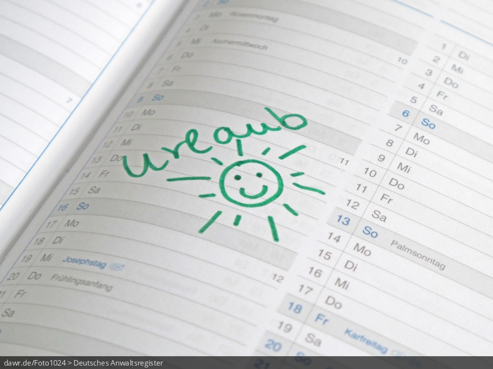 Dieses Foto zeigt den Ausschnitt einer Kalenderseite, auf die eine Sonne und das Wort Urlaub gemalt wurden.