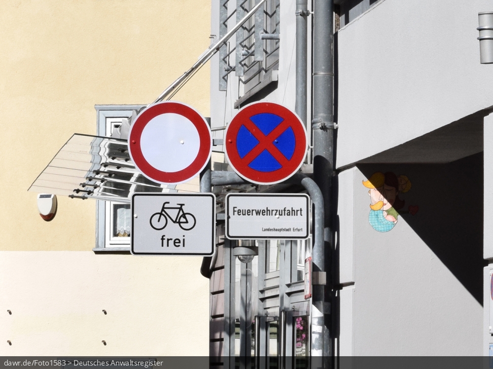 Dieses Foto zeigt u.a. ein Verkehrschild für ein absolutes Halteverbot mit dem ergänzenden Hinweis, dass dieses Halteverbot hier gilt, weil es sich um eine Feuerwehrzufahrt handelt. Immer wieder werden von Autofahrern oder auch Handwerkern Feuerwehrzufahrten teilweise oder gar ganz blockiert. Diese Darstellung kann als Illustration für dieses Thema gut geeignet sein.