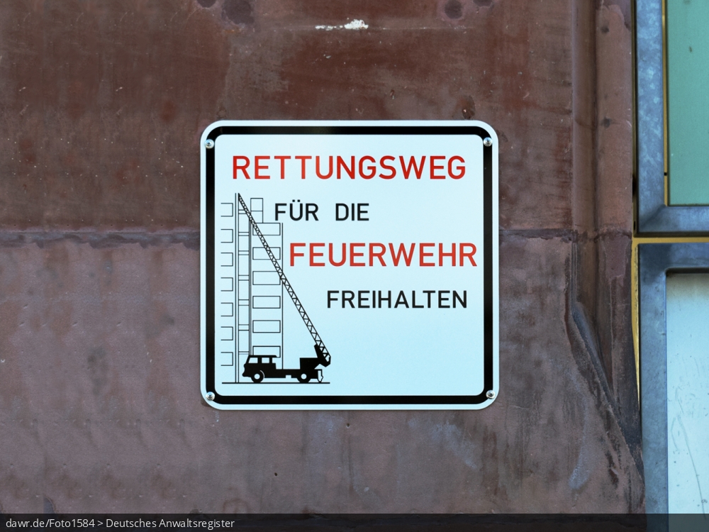 Dieses Foto zeigt ein Verkehrschild, dass dazu auffordert den hier verlaufenden Rettungsweg für die Feuerwehr frei zu halten. Immer wieder werden von Autofahrern oder auch Handwerkern Feuerwehrzufahrten teilweise oder gar ganz blockiert. Diese Darstellung kann als Illustration für dieses Thema gut geeignet sein.