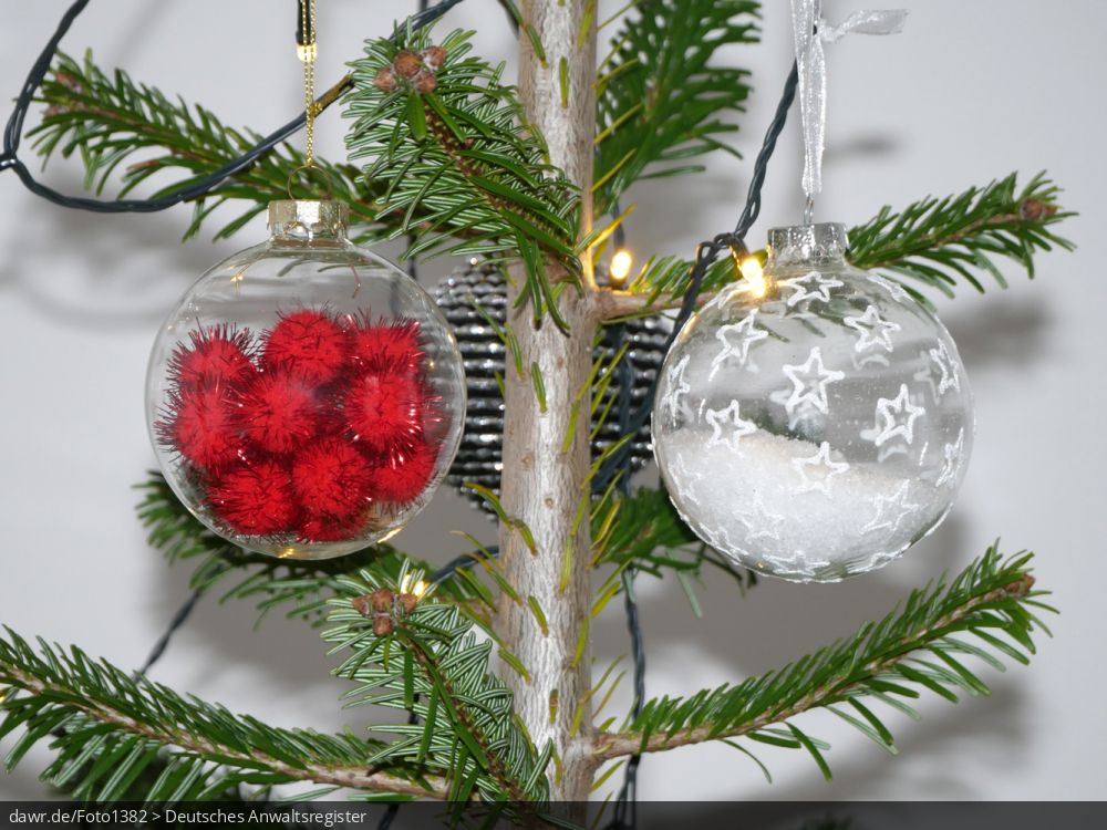 Dieses Foto zeigt zwei Weihnachtskugeln, wie sie an einem Weihnachtsbaum hängen. Diese Abbildung eignet sich gut als symbolische Darstellung für die Themen Weihnachten und Weihnachtsschmuck.