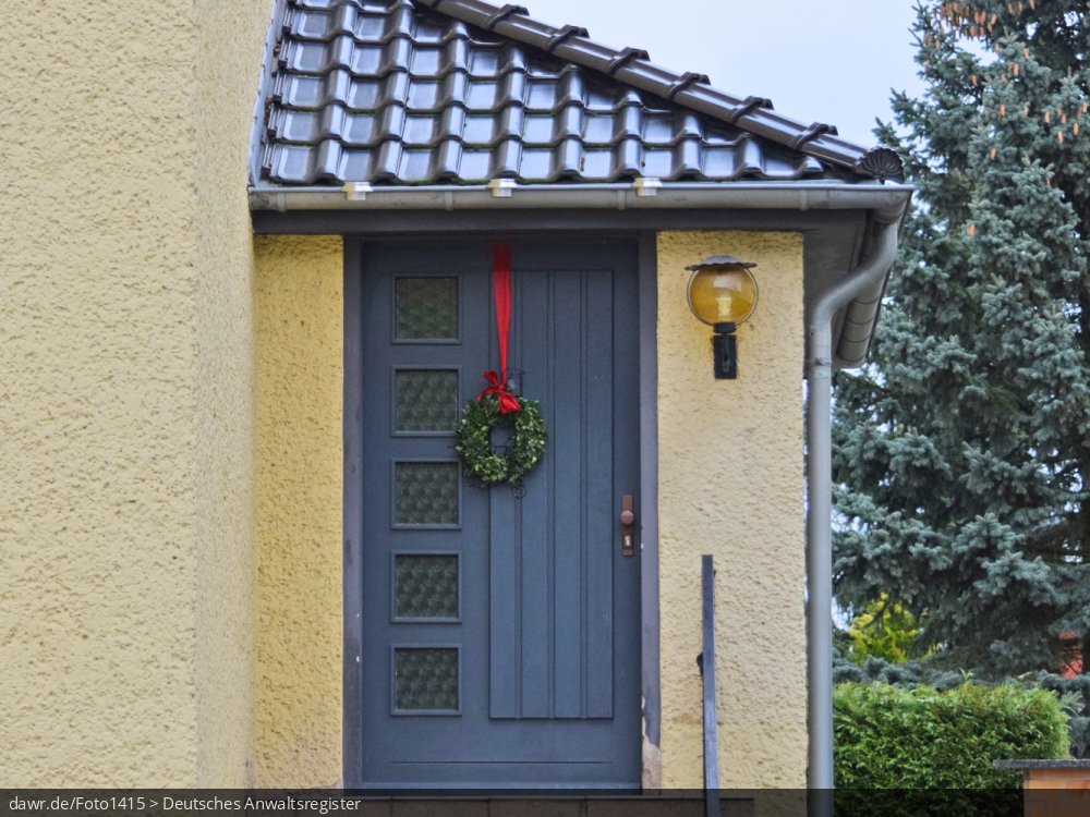 Dieses Foto zeigt einen Adventskranz an einer Haustür, wie er in ganz Deutschland zur Weihnachtszeit üblich ist. Dieses Bild eignet sich gut als symbolische Darstellung für alle Themen rund um Weihnachten und speziell zu rechtlichen Fragen bez. der Weihnachtsdekoration.