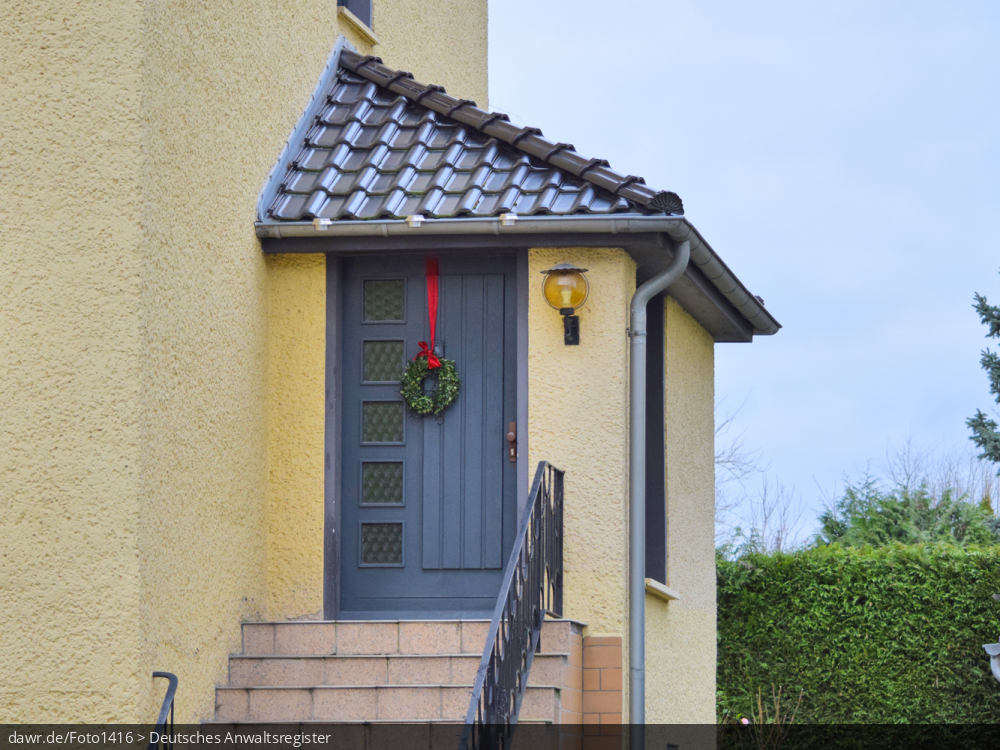 Dieses Foto zeigt einen Adventskranz an einer Haustür, wie er in ganz Deutschland zur Weihnachtszeit üblich ist. Dieses Bild eignet sich gut als symbolische Darstellung für alle Themen rund um Weihnachten und speziell zu rechtlichen Fragen bez. der Weihnachtsdekoration.