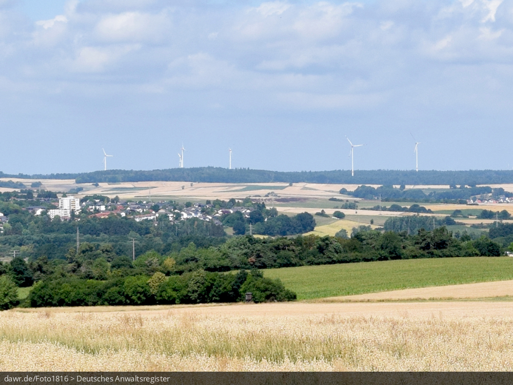 Dieses Bild zeigt einen Blick auf die Stadt Alsfeld im mittelhessischen Vogelbergskreis mit den am Horizont sichtbaren Windkraftanlagen. Es ergibt sich so ein passendes Bild für Themen rund um erneuerbare Energien, Windkraft oder allgemein der umweltfreundlichen Stromerzeugung.
