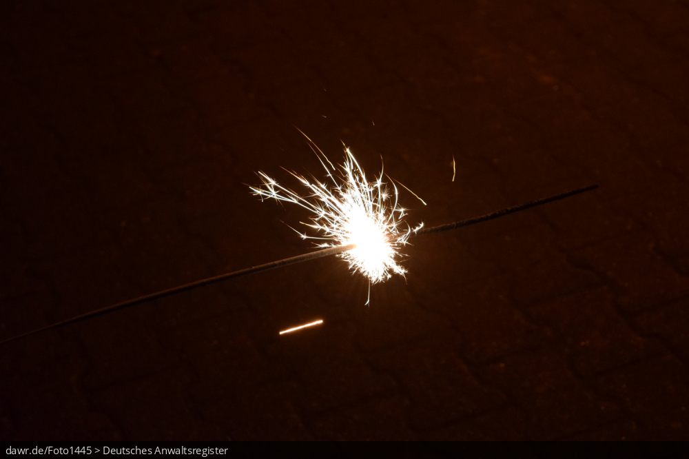 Dieses Foto zeigt eine brennende Wunderkerze in der Dunkelheit. Dieses Bild eignet sich gut als symbolische Darstellung für die Themen Silvester und Feuerwerk.