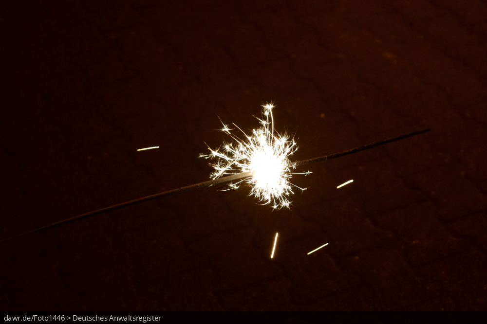 Dieses Foto zeigt eine brennende Wunderkerze in der Dunkelheit. Dieses Bild eignet sich gut als symbolische Darstellung für die Themen Silvester und Feuerwerk.