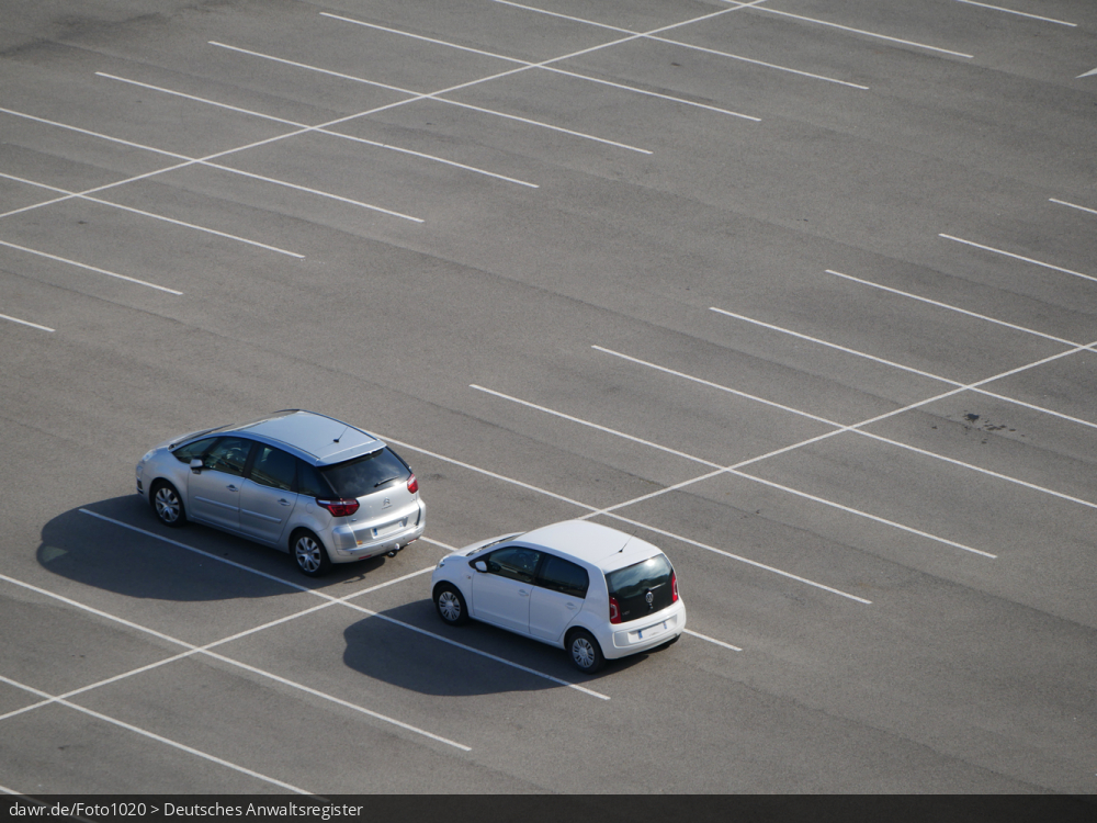 Dieses Foto zeigt zwei Autos auf einem leeren Parkplatz.