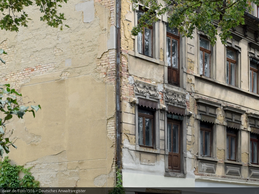 Dieses Foto zeigt eine baufälliges Wohnhaus mit bröckelndem Putz und abgebrochenen Balkonen, wie es in vielen (Klein)Städten zu finden ist. Die Gründe für einen solch schlechten Erhaltungszustand sind oft ungeklärte Eigentumsverhältnisse, ausbleibende staatliche Mittel oder einfach fehlende Investoren. Mit seinem schlechten Erhaltungszustand, kann dieses Gebäude symbolisch für Themen wie Wohnungsbau, Mietmängel oder auch Schrottimmobilien stehen.